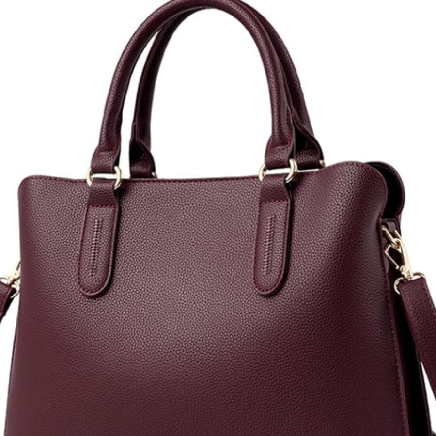 Metal feet on the base of the Wine Pebbled Satchel. Feet are cheap to add and they are the difference between a bag that wears at the corners and one that does not.